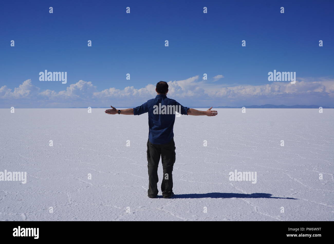 Embracing the beauty of the Bolivian Salt Flats with open arms and salt as far as the eye can see Stock Photo