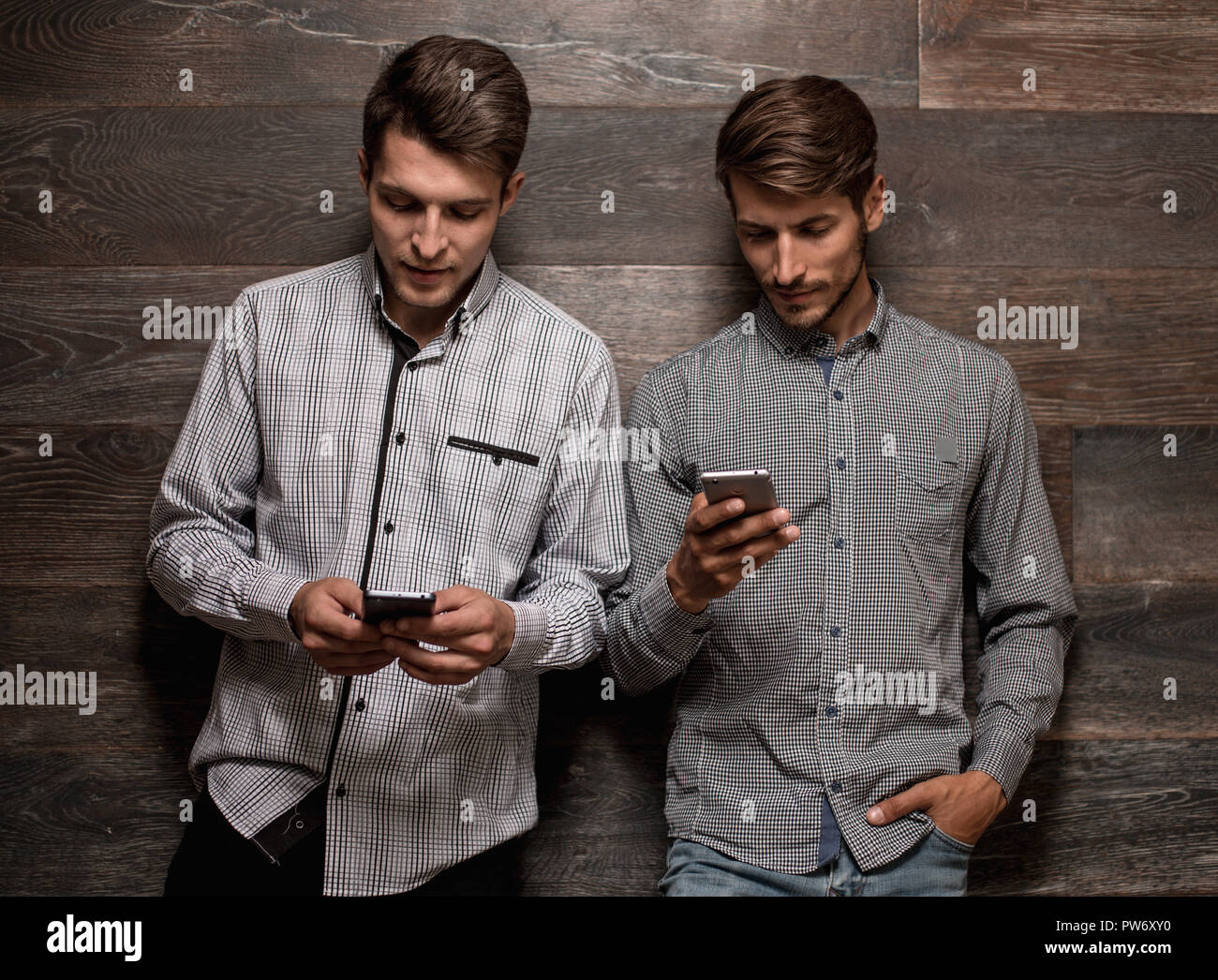 Portrait of two men in white shirts on dark background Stock Photo - Alamy