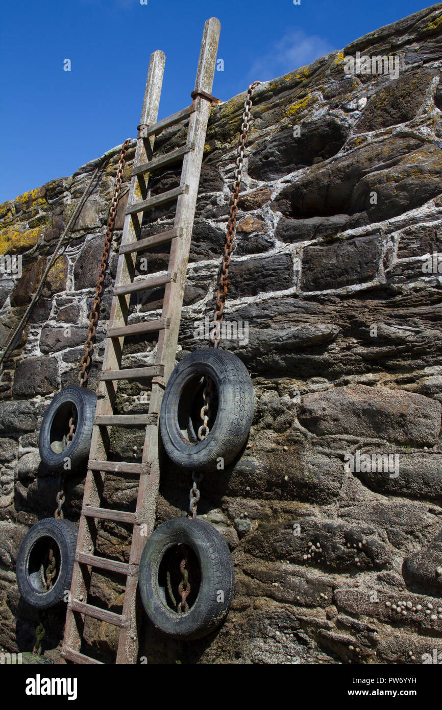 Ladder leaning against a harbour wall Stock Photo