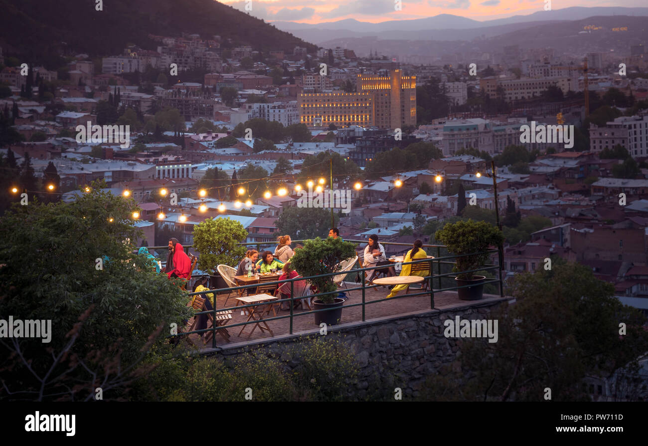 TBILISI, GEORGIA - JUNE 15, 2017: People are resting in a cafe on the terrace in the evening. Restaurant on the terrace. Chillout bar on the hill with Stock Photo