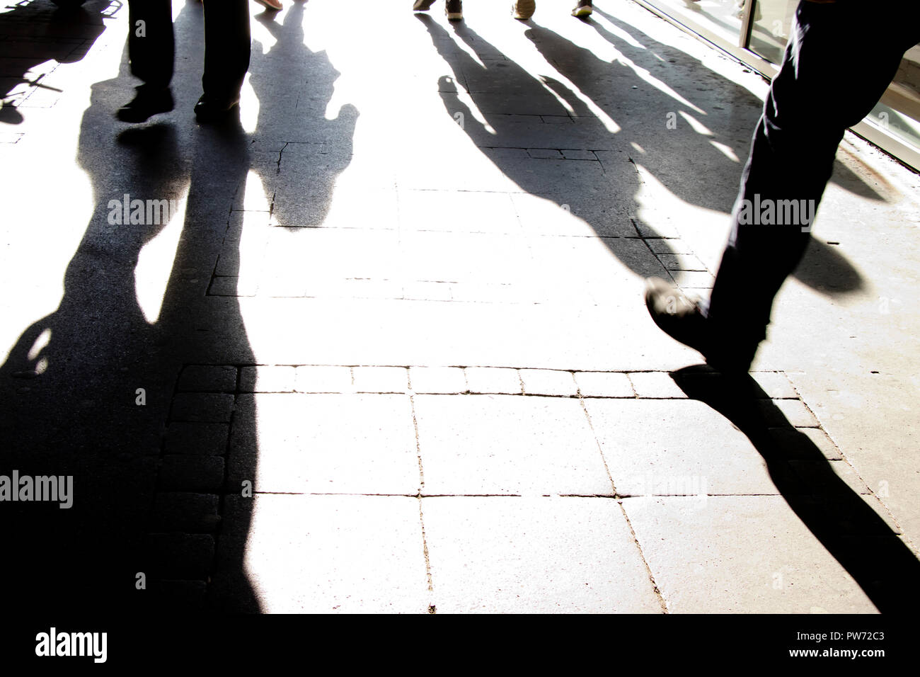 Silhouette shadows of people walking on city street in black and white ...