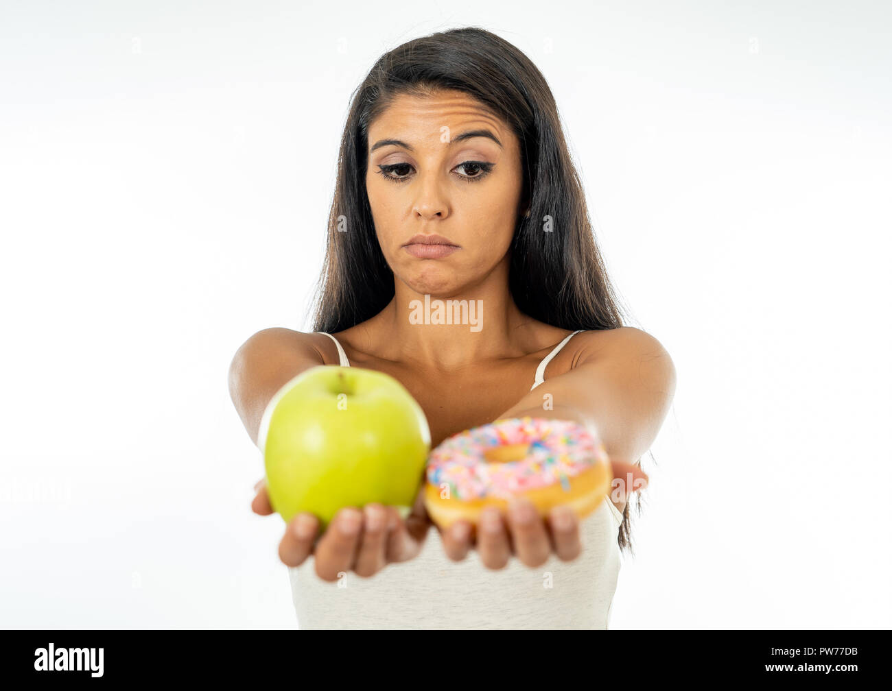 Beautiful young woman tempted having to make choice between apple and