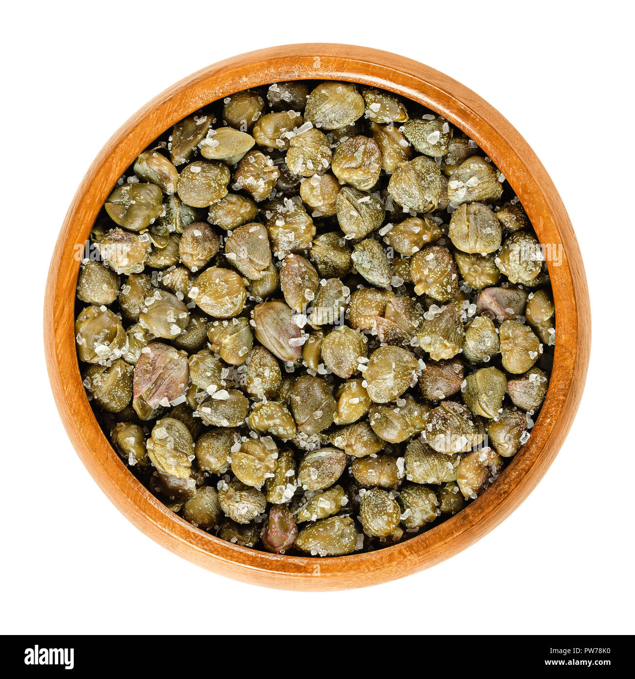 Salted capers in wooden bowl. Green, dried, pickled in sea salt, seasoning or garnish. Flower buds, capparis spinosa, caper bush, Flinders rose. Stock Photo