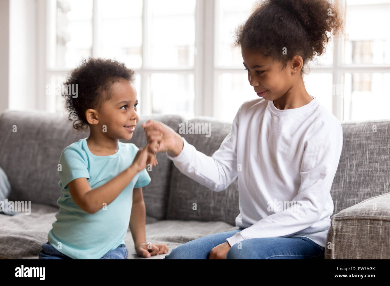 Brother and sister reconcile after fight joining pinkies Stock Photo
