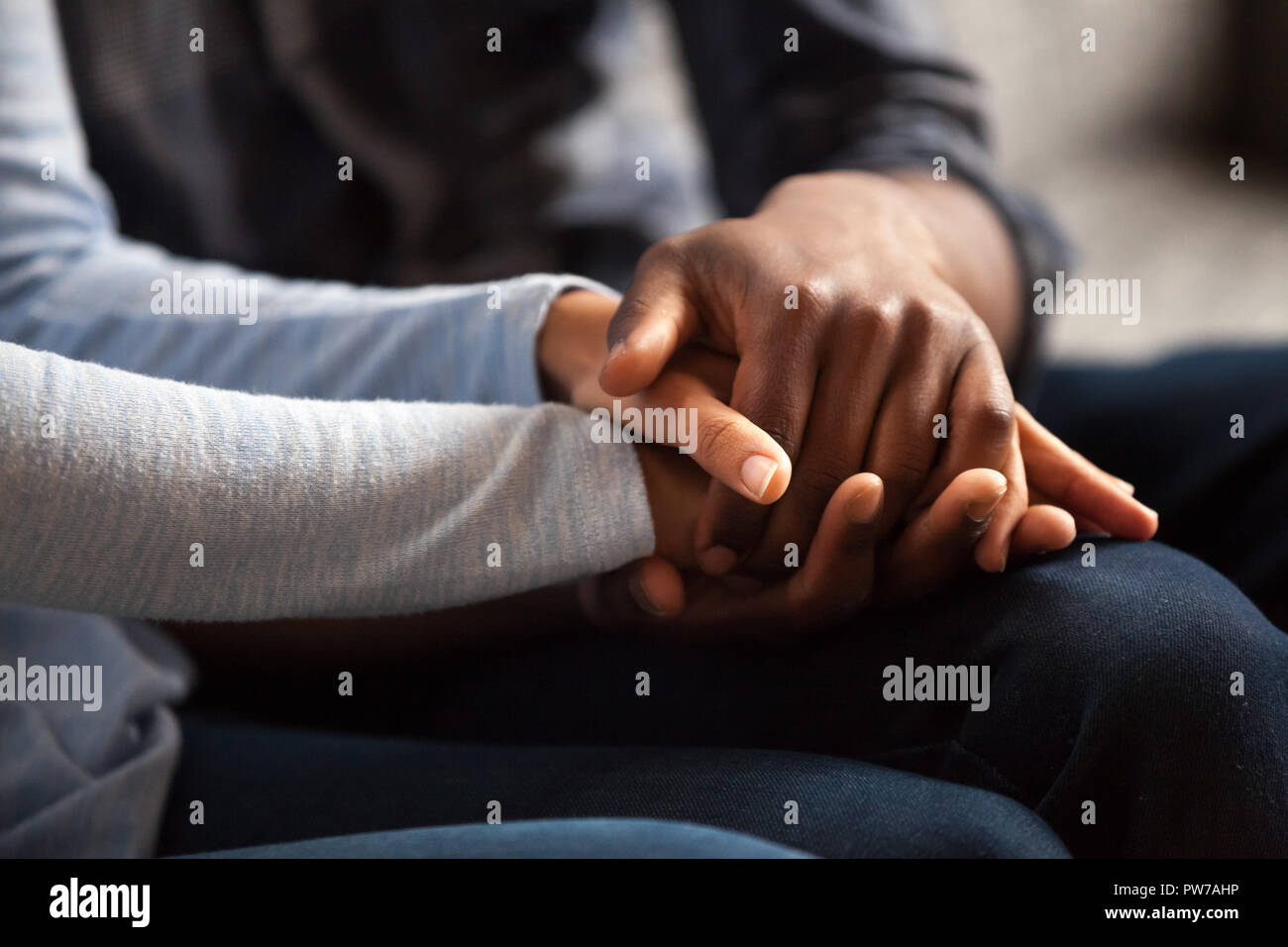 Close up black male and female holds hands Stock Photo - Alamy