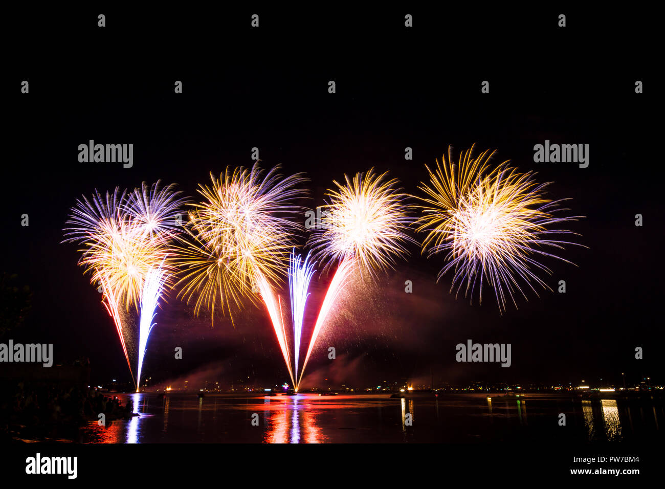 Giant firework fireballs over water surface Stock Photo