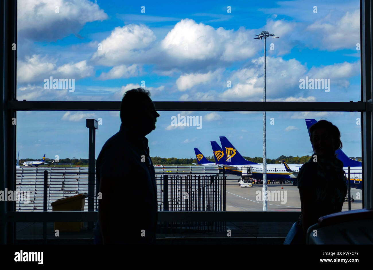 Passengers silhouetted against Ryanair Boeing 737 at London, Stansted airport, Stock Photo