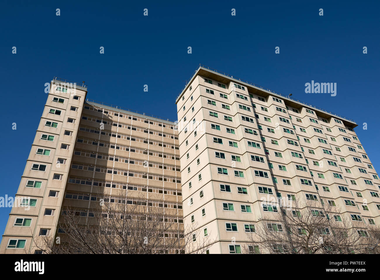 A council apartment block against a clear blue sky. Occupied predominantly by welfare recipients, immigrants and the elderly. Stock Photo