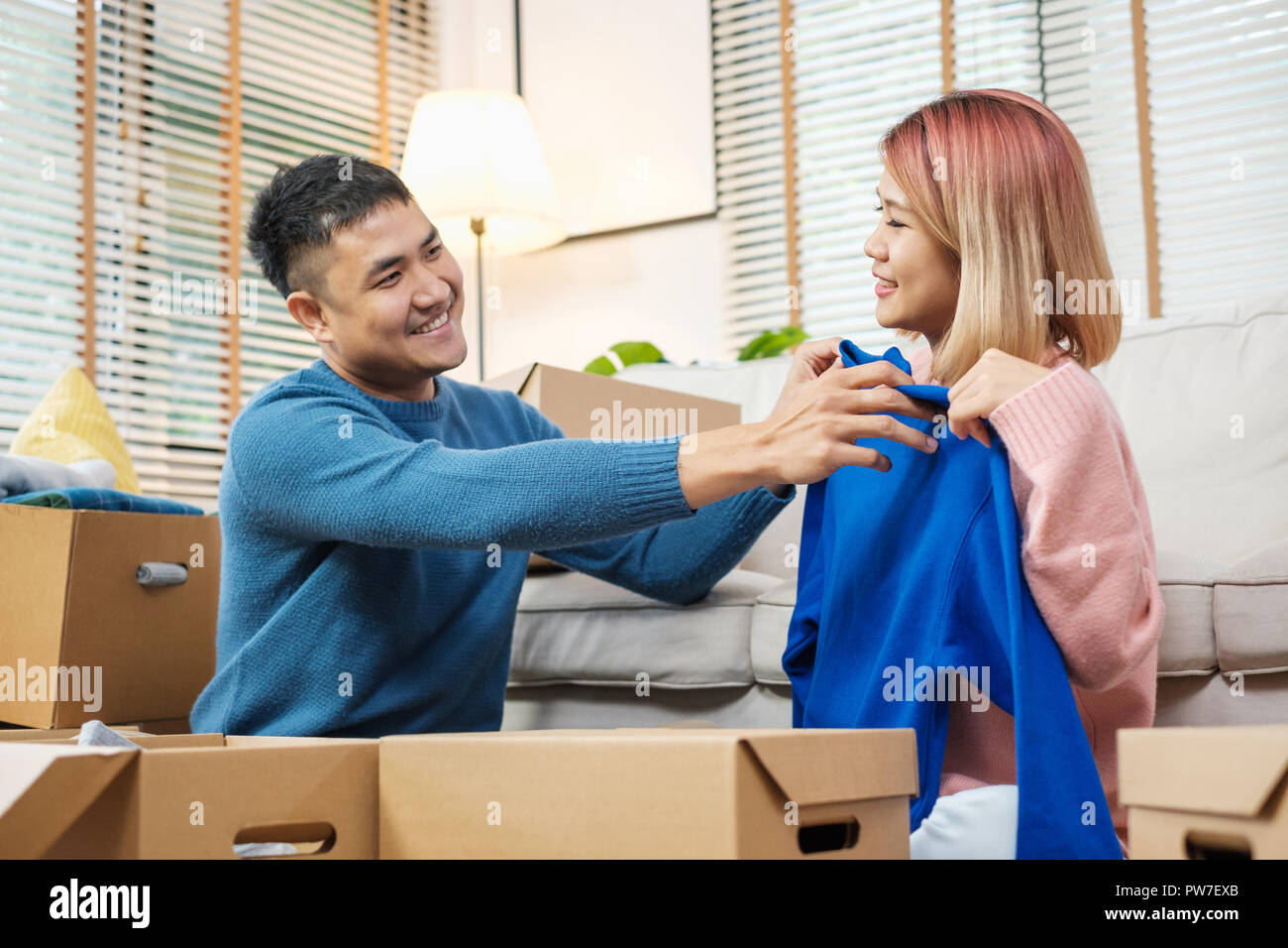 Happy asian couple open cardboard boxes while moving to new home at ...