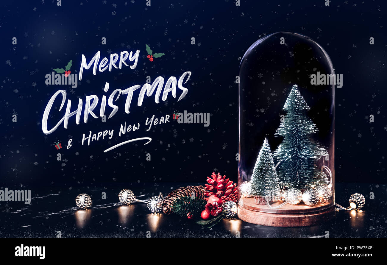 Merry Christmas and Happy new year with mistletoe and gift box icon with xmas tree and glowing light string and pine cone decoration on marble table a Stock Photo