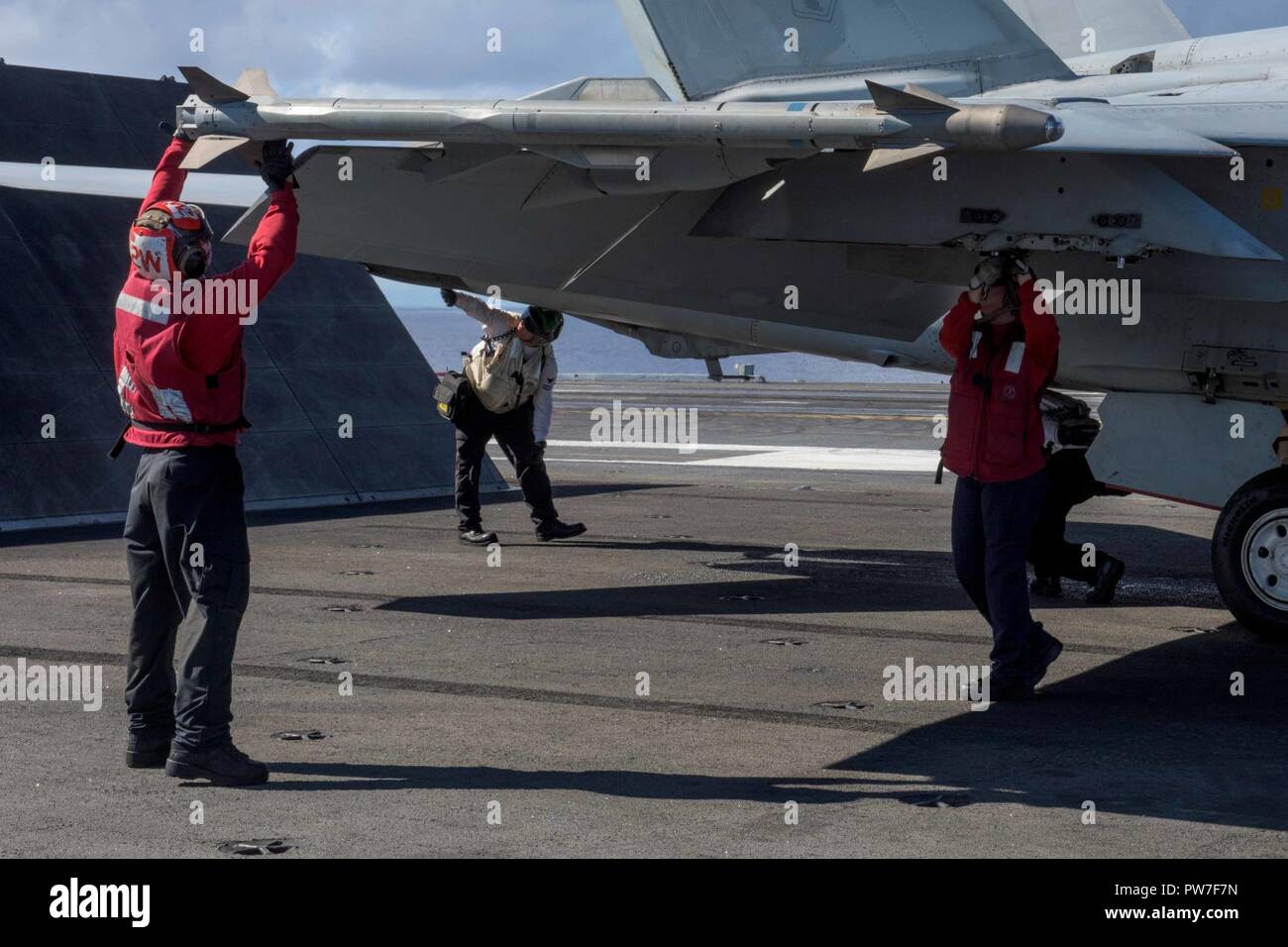 PHILIPPINE SEA (Sept. 20, 2017) Aviation Ordnancemen Qiong Wang, from Mountainview California, and Lorena Lucio, from Brownsville, Texas, inspect ordnance on an F/A-18E Super Hornet, assigned to Strike Fighter Squadron (VFA) 27, on the flight deck of the Navy's forward-deployed aircraft carrier, USS Ronald Reagan (CVN 76).  Ronald Reagan, the flagship of Carrier Strike Group 5, provides a combat-ready force that protects and defends the collective maritime interests of its allies and partners in the Indo-Asia-Pacific region. Stock Photo