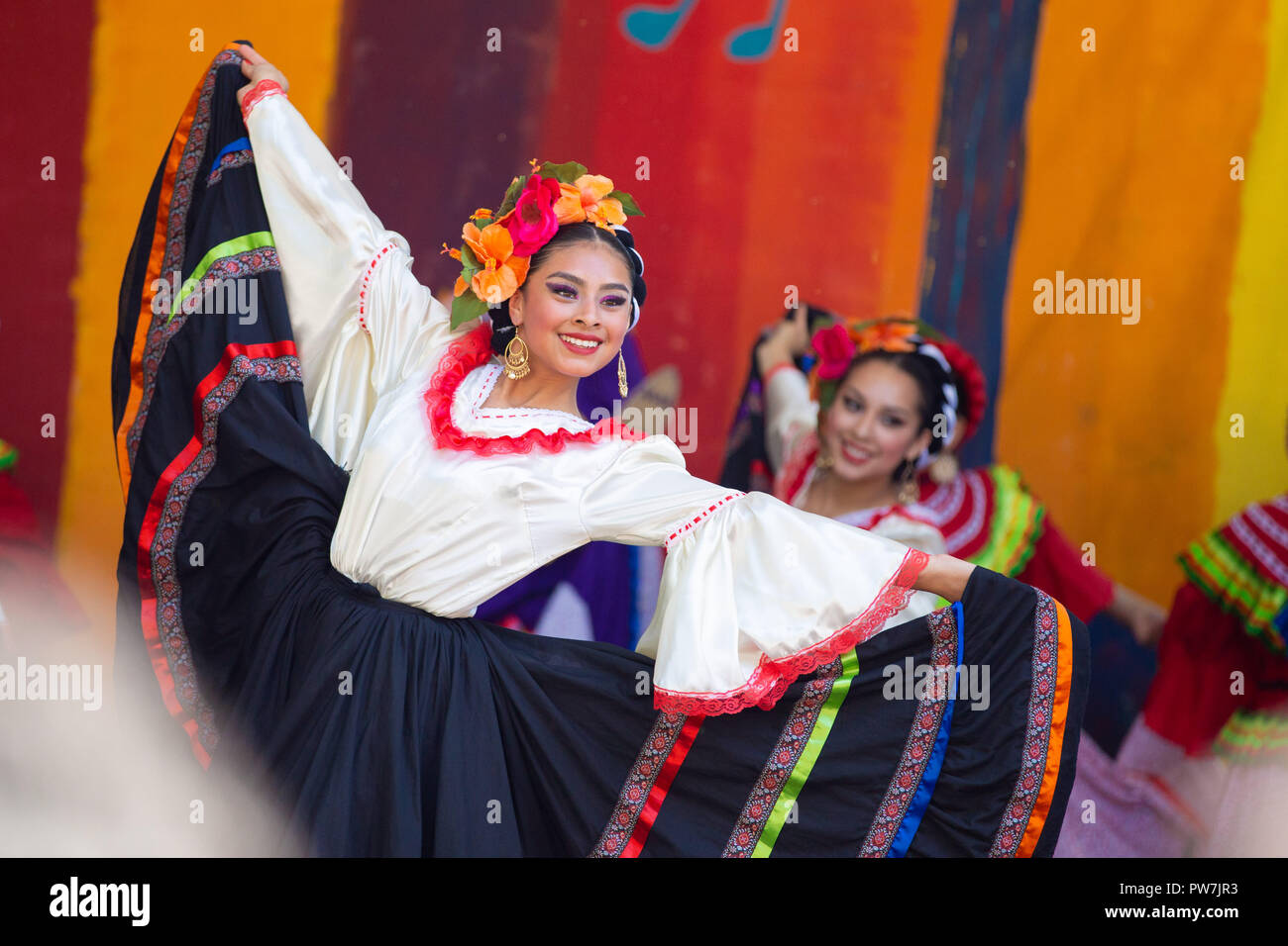 Portland, OR / USA - May 7 2016: Beautiful woman in a traditional latino costume dancing at the cinco de mayo celebration. Stock Photo