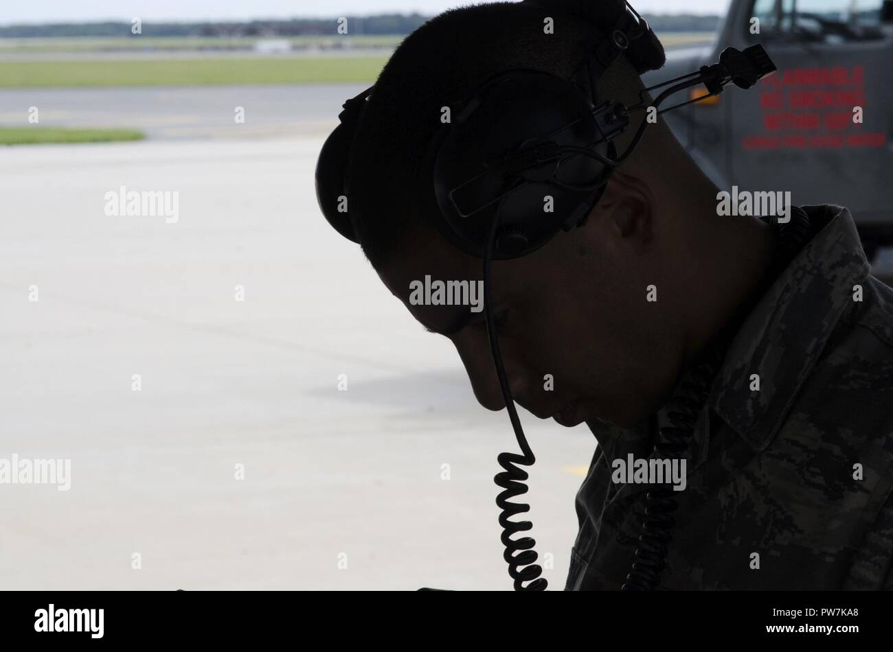 Silhoutte of Staff Sergeant Jonathan Carmona, crew chief, reviewing a technical order on the 108th Wing apron at Joint Base McGuire-Dix-Lakehurst, N.J., Sept. 20, 2017. Stock Photo