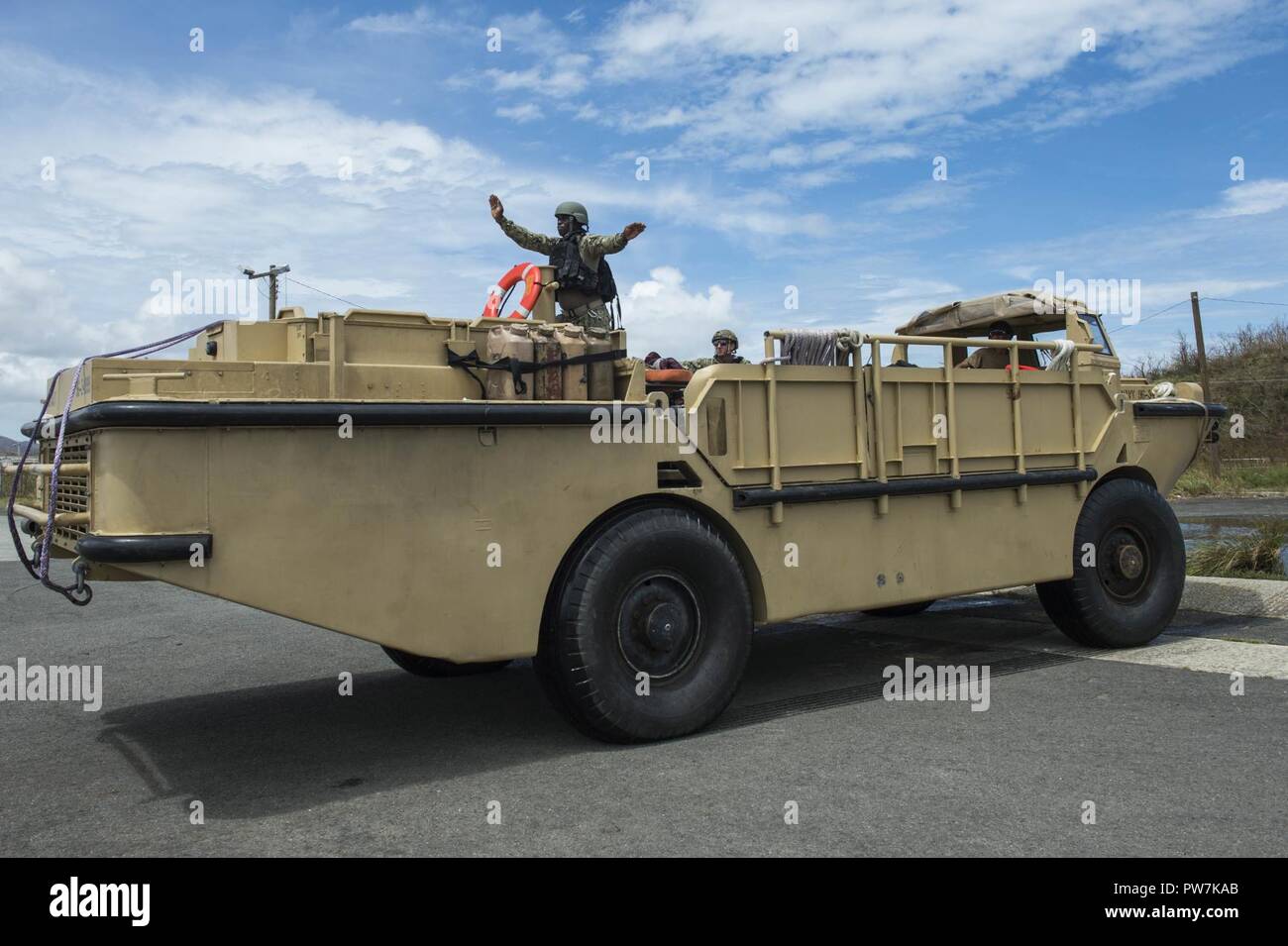 PUERTO RICO (Sept. 25, 2017) Boatswain’s Mate 3rd Class Ibrahima Thiaw, assigned to Beach Master Unit (BMU), guides a lighter amphibious resupply and cargo vehicle in Puerto Rico, Sept. 25, 2017. The Department of Defense is supporting Federal Emergency Management Agency (FEMA), the lead federal agency, in helping those affected by Hurricane Maria to minimize suffering and is one component of the overall whole-of-government response effort. Stock Photo