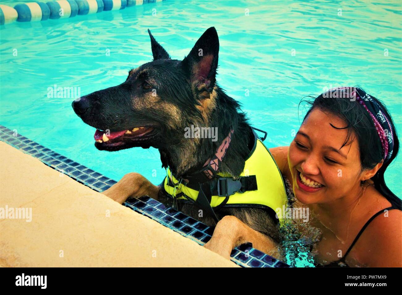 - Stephanie Flores cuddles up with her Labrador retriever mix during the third annual Doggy Swim Day September 23, 2017 at the Fort Bliss Community Pool. Flores looks forward to this event ever year. (Army Stock Photo