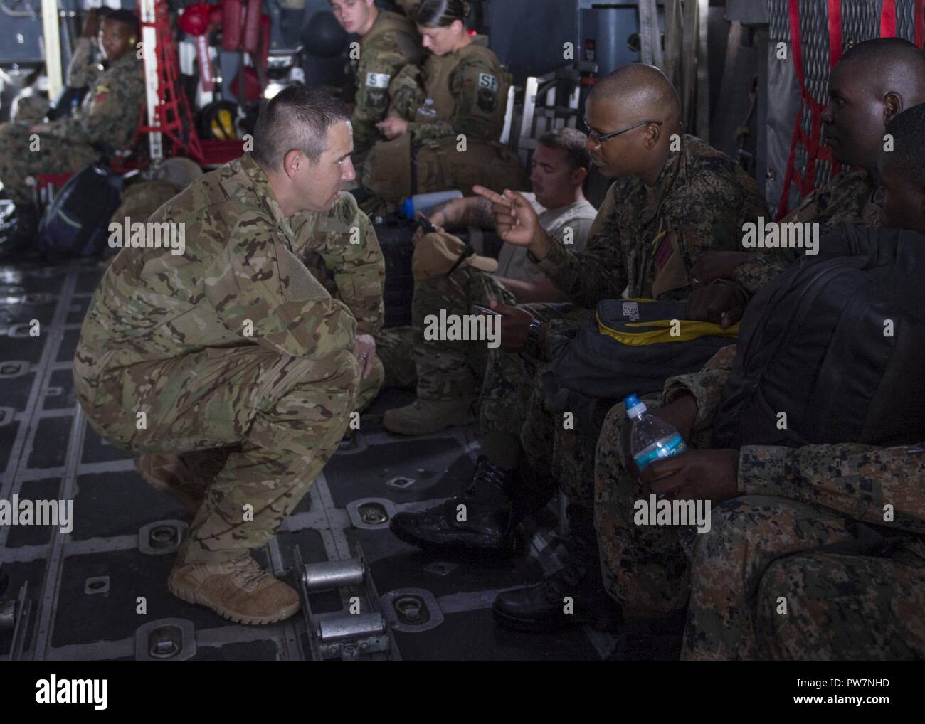 Lt. Col. Michael Compton, a mission commander from the 15th Special Operations Squadron, speaks with Jamaican Defense Force Damain Bromley, disaster response officer in charge, on board an MC-130H Combat Talon II at Grantley Adams International Airport, Barbados, Sept. 27, 2017. Air Commandos transported 25 Jamaican soldiers and five civilian disaster response workers from Team Rubicon Region III to Charles Douglas Airport, Dominica, while providing humanitarian aid after Hurricanes Irma and Maria devastated islands in the Caribbean. Stock Photo