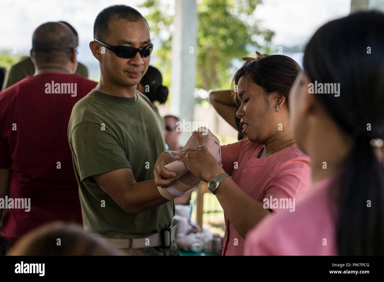 A local nurse treats a fake wound on U.S. Navy HM1 Froilan Bundalian's arm during first aid training as part of a cooperative health engagement at Tinib Elementary School in support of KAMANDAG in Casiguran, Aurora, Philippines, Sept. 25, 2017. KAMANDAG has ongoing bilateral humanitarian and civic assistance activities that enable American and Philippine service members to get to know each other and provide support to local communities. Bundalian is a lab technician with Medical Logistics Company, 3rd Supply Battalion, and is a native of Quezon City, Rizal, Philippines. Stock Photo