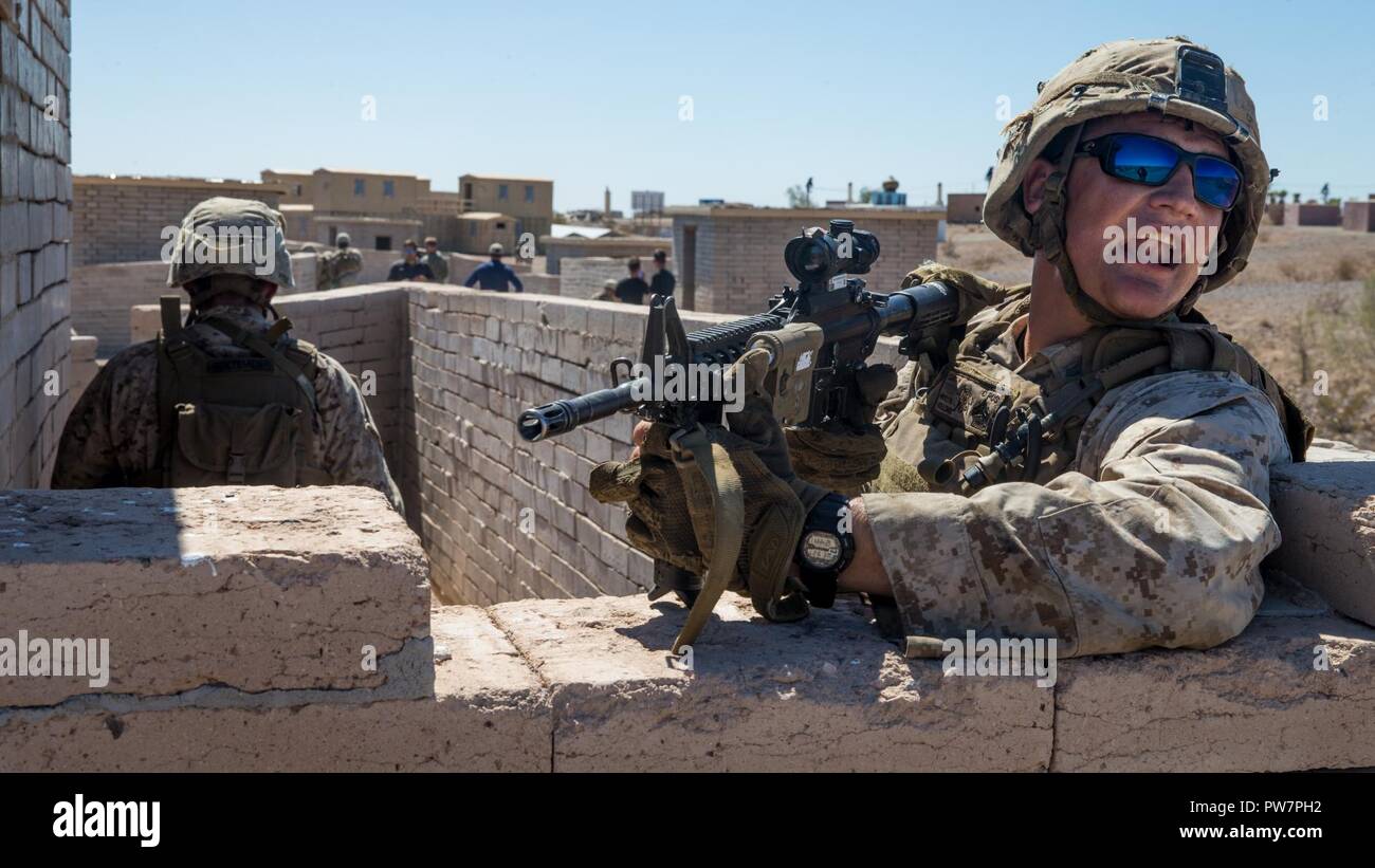 U.S. Marine Corps Lance Cpl. Clint J. Holloway, a machine gunner assigned to Kilo Company, 3rd Battalion, 1st Marines, conducts urban training during Weapons and Tactics Instructor Course (WTI) 1-18 in Yuma, Ariz., on Sept. 27, 2017. WTI is a seven week training event hosted by Marine Aviation Weapons Tactics Squadron One (MAWTS-1) cadre which emphasizes operational integration of the six functions of Marine Corps Aviation in support of a Marine Air Ground Task Force. MAWTS-1 provides standardized advanced tactical training and certification of unit instructor qualifications to support Marine  Stock Photo