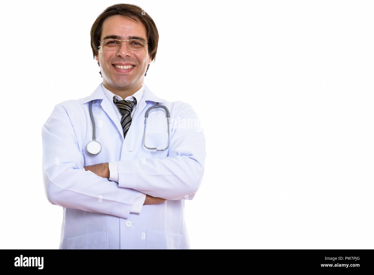 Studio shot of young happy Persian man doctor smiling and wearin Stock Photo