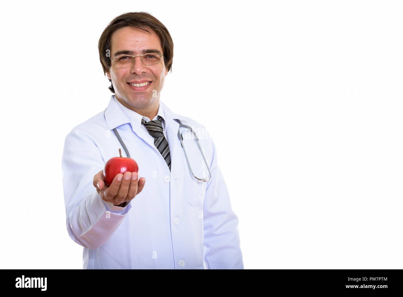 Studio shot of young happy Persian man doctor smiling while givi Stock Photo