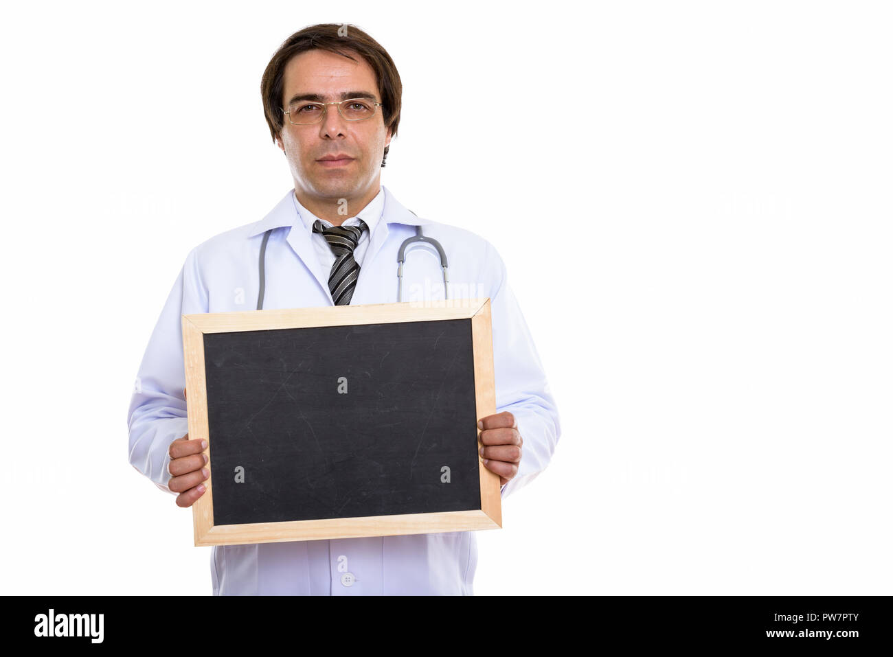 Studio shot of young Persian man doctor holding blank blackboard Stock Photo