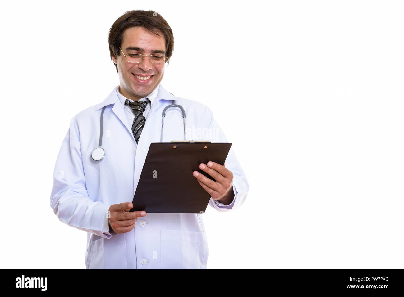 Studio shot of young happy Persian man doctor smiling while read Stock Photo