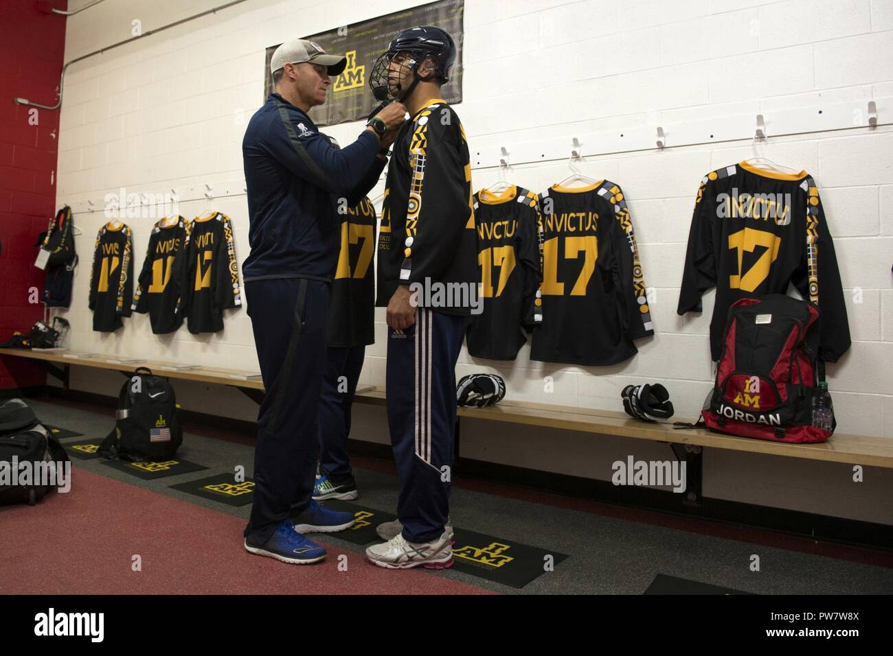 U.S. Special Operations Command’s Army Sgt. 1st Class Brant Ireland of Team US, left, prepares his team mate Salahuddin Zahireof Team Afghanistan for a 2017 Invictus Games sledge hockey game as an exhibition match at the Master Card Centre for Training Excellence in Toronto, Canada Sept. 29, 2017.  Many nations came together to form the Invictus sledge hockey exhibition team. Stock Photo