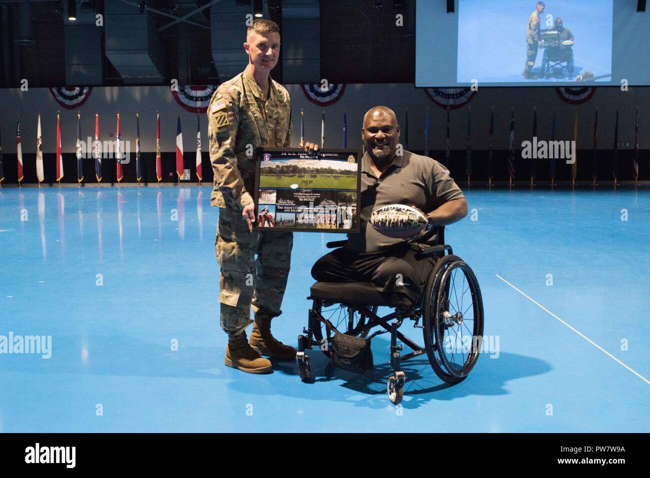 Retired U.S. Army Col. Gregory D. Gadson, former garrison commander of U.S. Army Fort Belvoir, is presented an Old Guard frame by Col. Jason T. Garkey, Commander, 3d U.S. Infantry Regiment (The Old Guard) during a speaking event with Soldiers of The Old Guard in Conmy Hall, Joint Base Myer-Henderson Hall, Va., Sept. 28, 2017. Col. Gadson is a bilateral above-the-knee amputee, occasional actor, and motivational speaker who served in the U.S. Army for over 20 years. Stock Photo