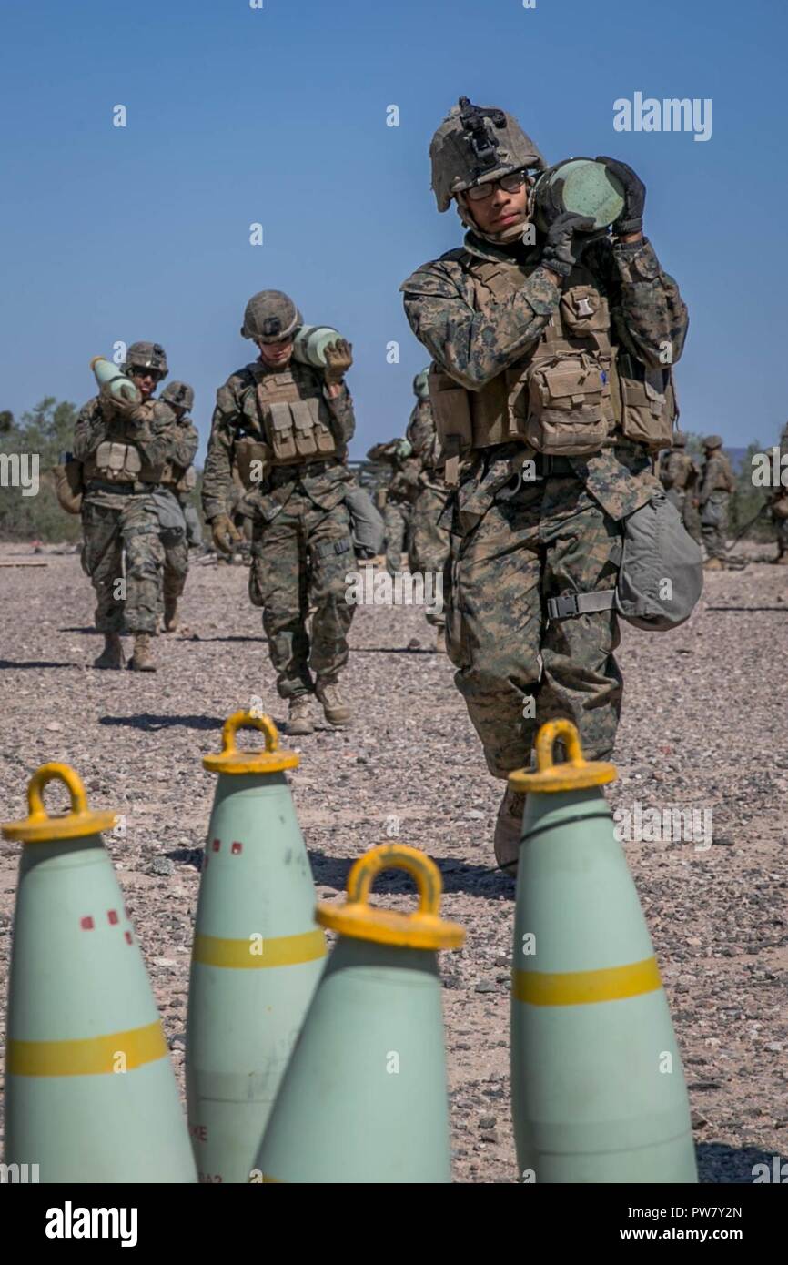 U.S. Marine Corps Lance Cpl. Francisco Munguiaandrade, a field artillery Marine with Echo Battery, 2nd Battalion, 11th Marine Regiment, carries ammunition for a M777 towed 155 mm howitzer during Weapons and Tactics Instructors Course (WTI) 1-18 at Yuma, Ariz., on Sept. 30, 2017. WTI is a seven week training event hosted by Marine Aviation and Weapons Tactics Squadron One (MAWTS-1) cadre which emphasizes operational integration of the six functions of Marine Corps Aviation in support of a Marine Air Ground Task Force. MAWTS-1 provides standardized advanced tactical training and certification of Stock Photo