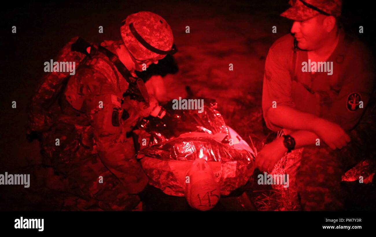 U.S. Army Staff Sgt. Eric Joiner, assigned to the Lyster Army Community Hospital, reassesses a simulated casualty during the 2017 Best Medic Competition at Fort Bragg, N.C., Sep. 18-21, 2017. The competition tested the physical and mental toughness, as well as the technical competence, of each medic to identify the team moving forward to represent the region at the next level of the competition. Stock Photo