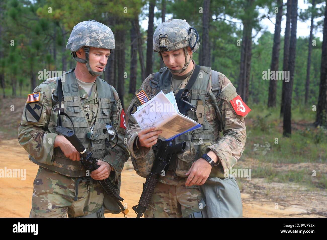U.S. Army Sgt. 1st Class Zachary Dispennette and Sgt. Christopher Faulkner, both assigned to the McDonald Army Health Center, discuss a plan during the 2017 Best Medic Competition at Fort Bragg, N.C., Sep. 18-21, 2017. The competition tested the physical and mental toughness, as well as the technical competence, of each medic to identify the team moving forward to represent the region at the next level of the competition. Stock Photo