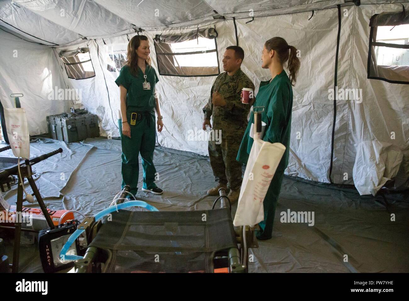 U.S. Navy Hospitalman 3rd Class Juan Barajas, corpsman, Charlie Company, 1st Medical Battalion, talks to nurses about the surgical tent portion of the Shock Trauma Platoon (STP) Field Surgical Tent capabilities and how they can be used in crisis response situations  at the Zuckerberg San Francisco General Hospital and Trauma Center Oct. 2, 2017. The STP Field Surgical Tent is used as an initial trauma care center designed to treat and stabilize patients prior to being moved to follow on care in a field environment. Stock Photo