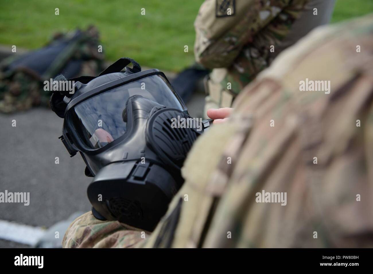 A U.S. Soldier with 39th Strategic Signal Battalion checks an M50 joint service general purpose mask for Commander's Prime Time Training: after a 12-Mile ruck march, Soldiers go through the Chemical Biological Radiological Nuclear (CBRN) room, and practice shooting on the Engagement Skills Trainer 2 with protective gear, on Chièvres Air Base, Belgium, Aug. 20, 2017. Stock Photo