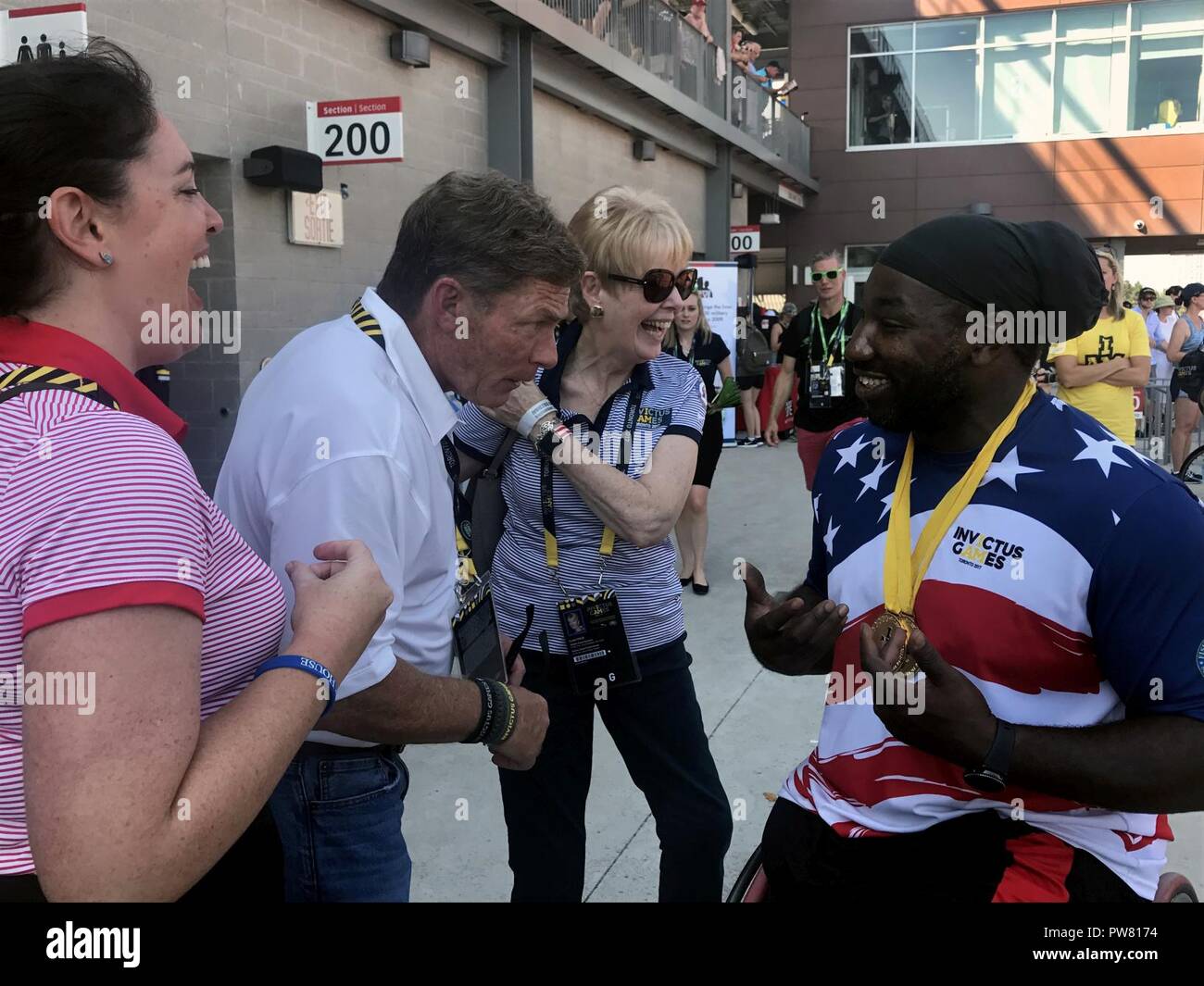 Ken Fisher, CEO and founder of Fisher House, jokes with medically retired Army Spc. Tony Pone, after he earned gold medals in his disability category in the men’s discus and shot put during the 2017 Invictus Games in Toronto Sept. 24, 2017. The Invictus Games, established by Prince Harry in 2014, brings together wounded and injured veterans from 17 nations for 12 adaptive sporting events, including track and field, wheelchair basketball, wheelchair rugby, swimming, sitting volleyball, and new to the 2017 games, golf. Stock Photo