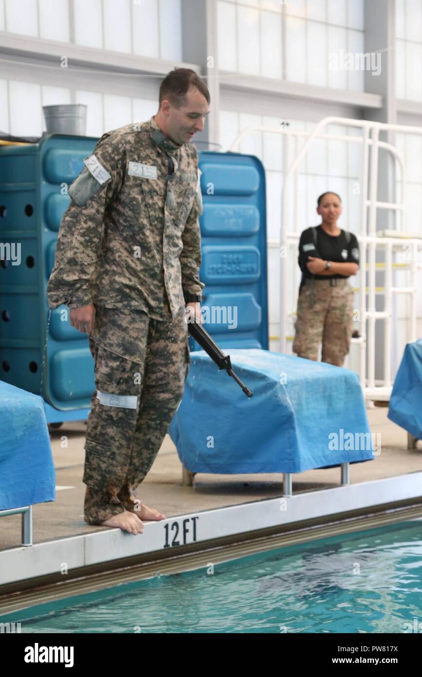 U.S. Army Sgt. Christopher Faulkner, assigned to the McDonald Army Health Center, prepares to step into the pool during the 2017 Best Medic Competition at Fort Bragg, N.C., Sept. 19, 2017. The competition tested the physical and mental toughness, as well as the technical competence, of each medic to identify the team moving forward to represent the region at the next level of the competition. Stock Photo