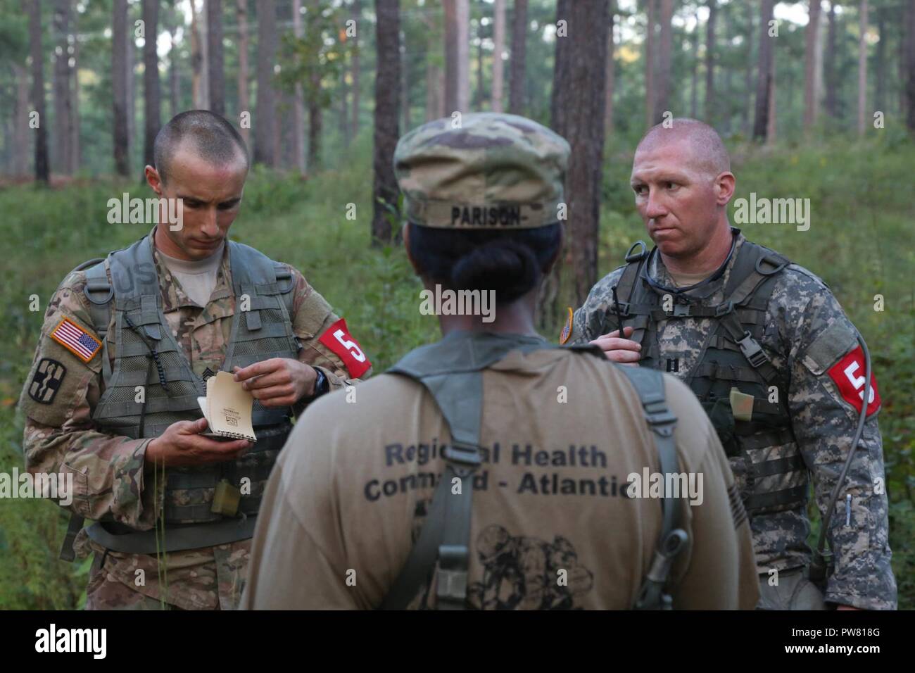 U.S. Army Staff Sgt. Joseph Karslo and Capt. Jeremy Lewis, assigned to the Public Health Command - Atlantic, listen to instructions during the 2017 Best Medic Competition at Fort Bragg, N.C., Sept. 19, 2017. The competition tested the physical and mental toughness, as well as the technical competence, of each medic to identify the team moving forward to represent the region at the next level of the competition. Stock Photo