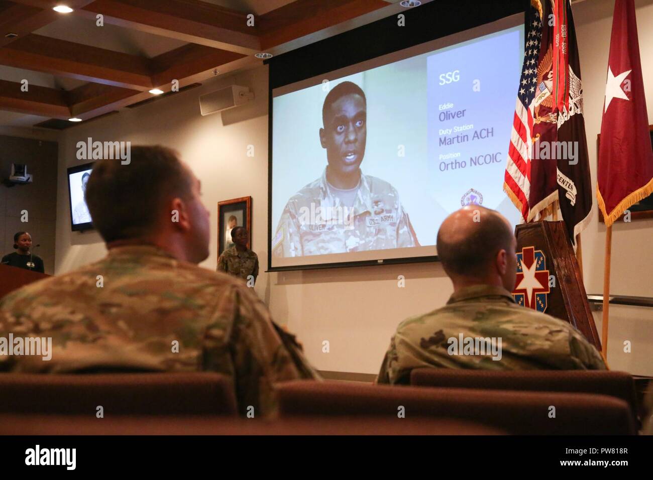 U.S. Army Sgt. Christopher Faulkner and Sgt. 1st Class Zachary Dispennette, assigned to the McDonald Army Health Center, watch the Best Medic Video during the 2017 Best Medic Competition Award Ceremony at Fort Bragg, N.C., Sept. 20, 2017. The competition tested the physical and mental toughness, as well as the technical competence, of each medic to identify the team moving forward to represent the region at the next level of the competition. Stock Photo