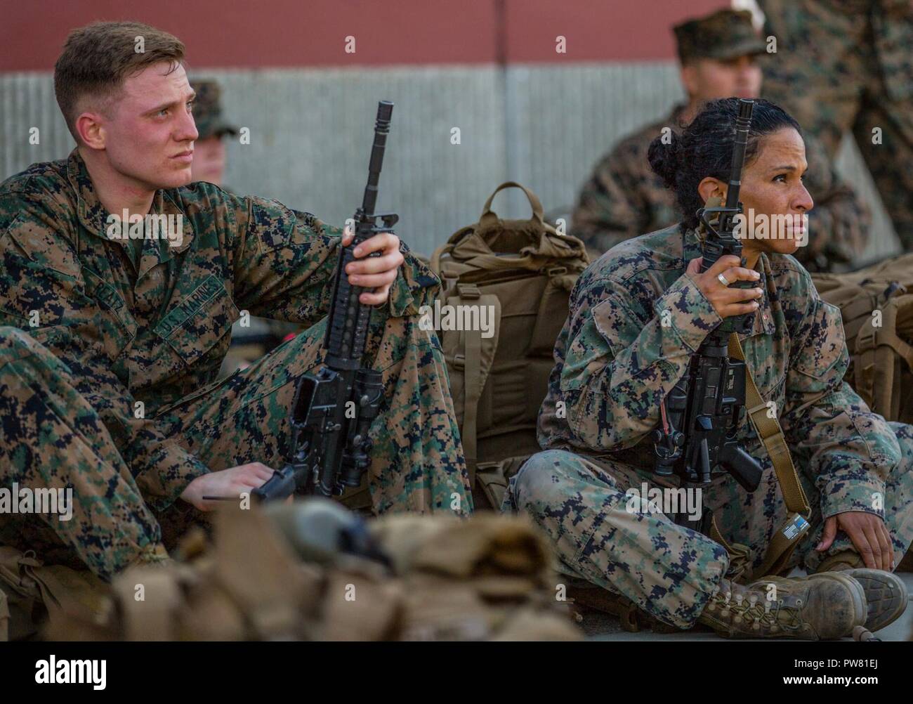 Camp Pendleton (September 29, 2017) Staff Sgt. Daniel J. Reatz (left) a cyber security technician and Chief Warrant Officer Three Serena M. Trice (right) an intelligence master analyst with the 11th Marine Expeditionary Unit (MEU), listen as the commanding officer of the MEU congratulates the Marines for successfully completing a conditioning hike on Camp Pendleton, California. The purpose of the conditioning hike is to target key areas, which are involved with propelling the body forward while also improving cardiovascular fitness, endurance, flexibility, strength and most importantly unit co Stock Photo