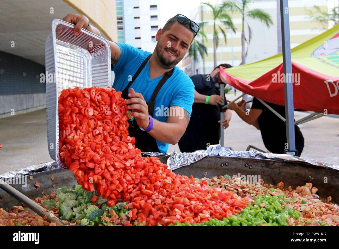 Alejandro Torres, a chef volunteering with a non-profit organization World Central Kitchen, prepares a dish for residents at the José Miguel Agrelot Coliseum in San Juan, Puerto Rico, Oct. 3, 2017. WCK prepared to feed approximately 46,000 residents. Chef Jose Andres, the founder of WCK, supported the Federal Emergency Management Agency by helping those affected by Hurricane Maria to minimize suffering as part of the overall whole-of-government response efforts. Stock Photo