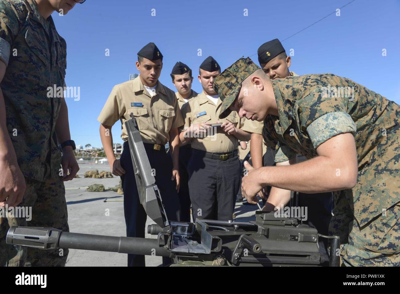 SAN FRANCISCO (Oct. 2, 2017) Lance Cpl. Nathan Colter, assigned to the 2nd Battalion, 5th Marines, demonstrates the operation of an MK19 grenade launcher to students of the Turlock High School Navy Junior Reserve Officers Training Corps during Fleet Week San Francisco. Fleet week provides an opportunity for the American public to meet their Navy, Marine Corps, and Coast Guard team and to experience America’s sea services. Fleet Week San Francisco will highlight naval personnel, equipment, technology, and capabilities, with an emphasis on humanitarian assistance and disaster response. Stock Photo