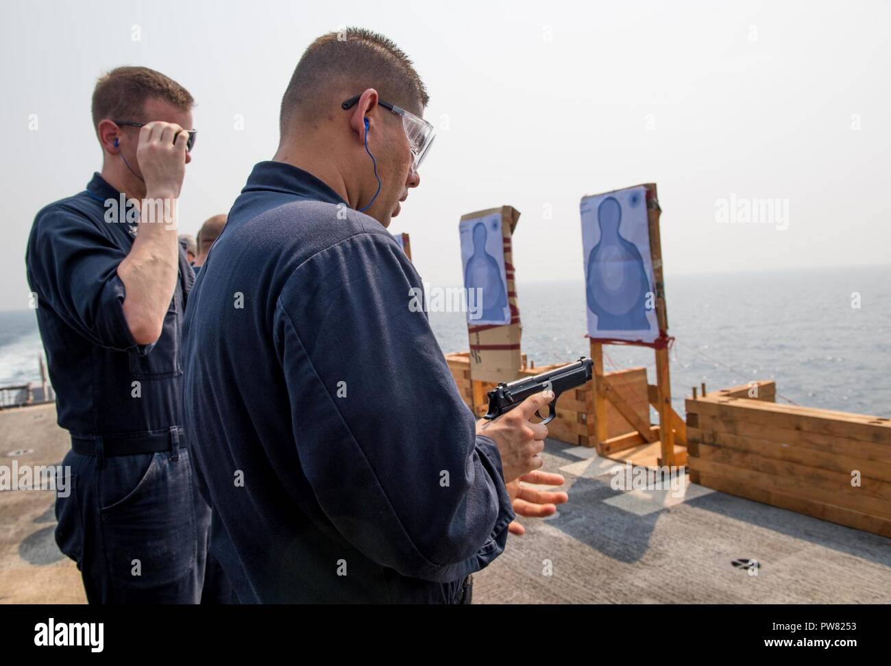 ARABIAN GULF (Sept. 19, 2017) Logistics Specialist 2nd Class Francisco MunizPerez, from Cabo Rojo, Puerto Rico, inserts a magazine into an M9 pistol during a small arms qualification course on the flight deck aboard the Ticonderoga-class guided-missile cruiser USS Princeton (CG 59). Princeton is deployed in the U.S. 5th Fleet area of operations in support of maritime security operations designed to reassure allies and partners, and preserve the freedom of navigation and the free flow of commerce in the region. Stock Photo