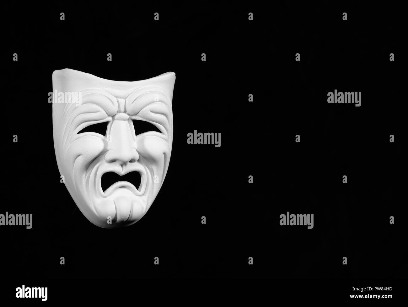 theatre mask expresing the tragedy, white mask on black background with free space for text Stock Photo