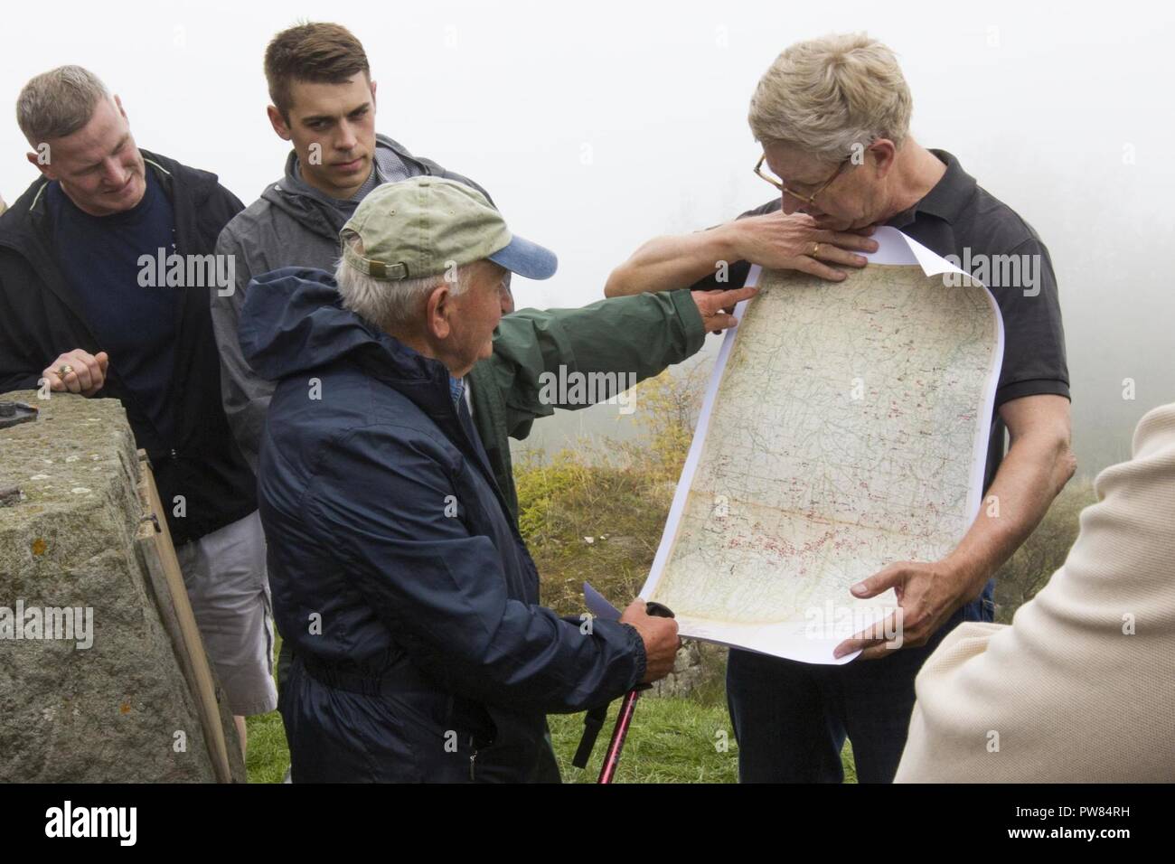 Elio Pasquale, an 83 year-old Italian local who remembered WWII and wears a 10th Mountain Division hat everywhere he goes, points out fighting positions on a map of the area at Mount Belvedere, Italy, on October 1. The group was on a tour that retraced the history of their Division by visiting WWII battlefields and signifcant sites to gain a deeper understanding, appreciation, and connection to the Division. Stock Photo