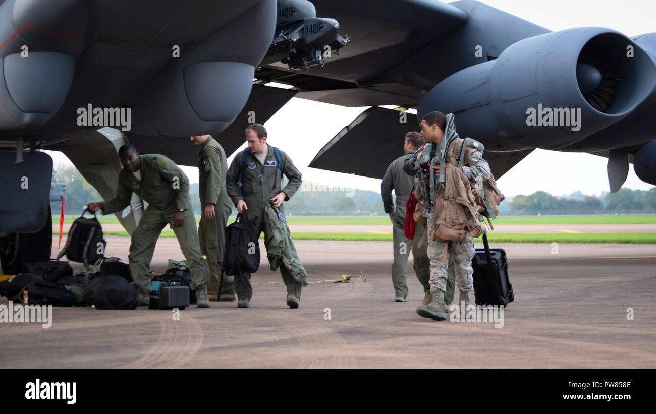 Aircrew retrieve their gear from a B-52 Stratofortress on RAF Fairford, United Kingdom, Sept. 26, 2017. The deployment of strategic bombers to the United Kingdom helps exercise RAF Fairford as U.S. Air Forces in Europe’s forward operating location for bombers. The deployment will also include joint and allied training to improve bomber interoperability. Training with joint partners, allied nations and other U.S. Air Force units contributes to our ready and postured forces and enables us to build enduring and strategic relationships necessary to confront a broad range of global challenges. Stock Photo