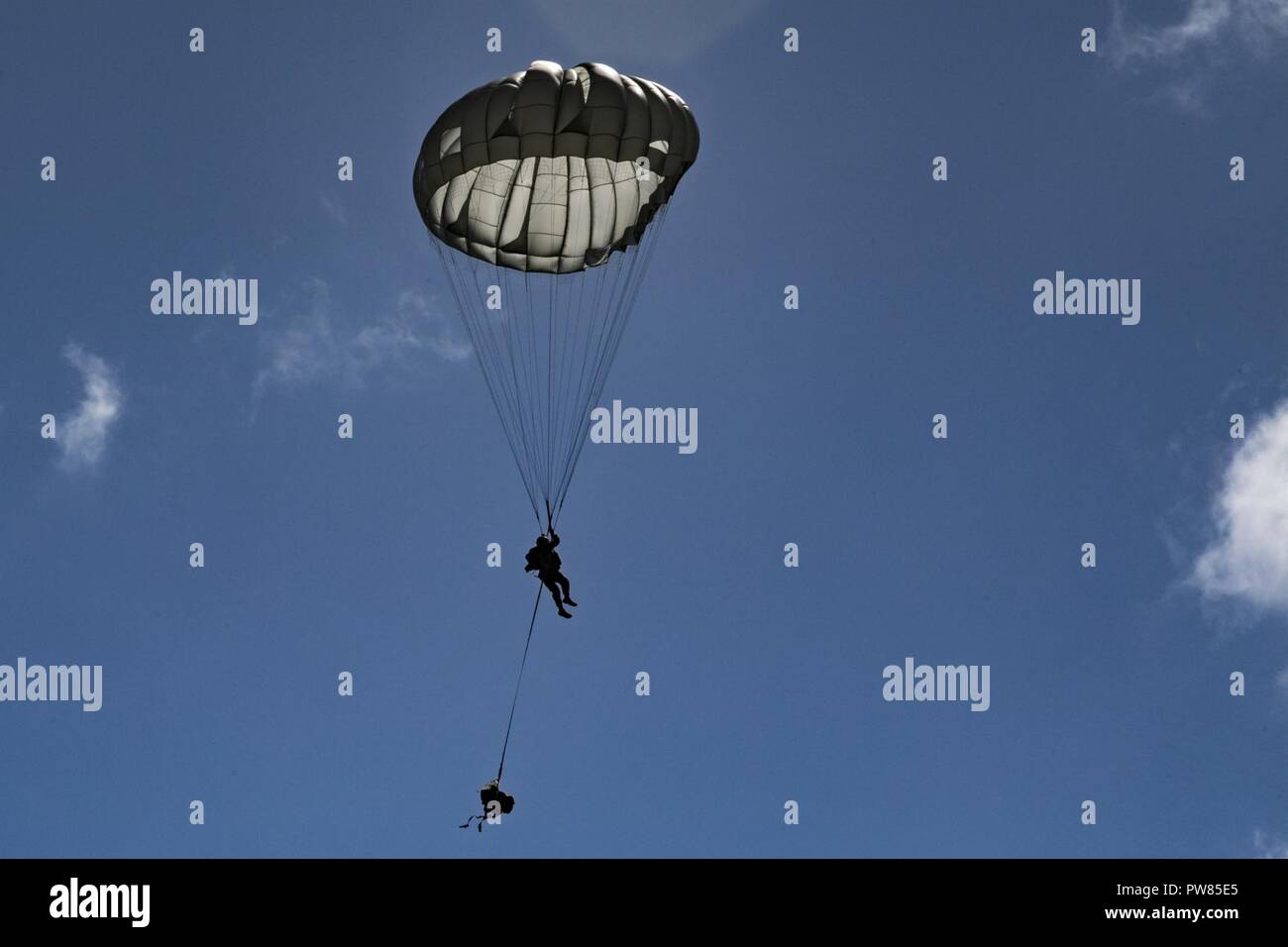 A member of the 820th Base Defense Group descends during a static-line jump, Oct. 3, 2017, at the Lee Fulp drop zone in Tifton, Ga. During a static-line jump, the jumper is attached to the aircraft via the ‘static-line’, which automatically deploys the jumpers’ parachute after they’ve exited the aircraft. Stock Photo