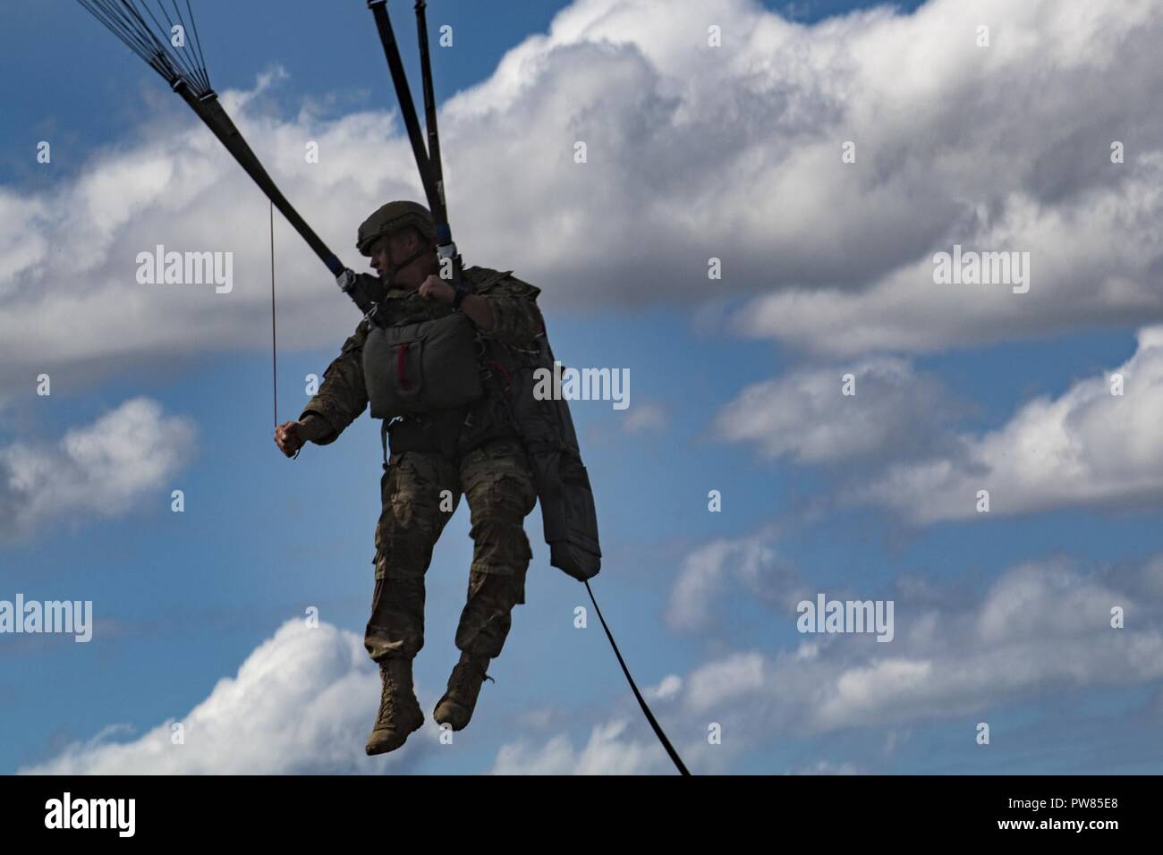 A member of the 820th Base Defense Group descends during a static-line jump, Oct. 3, 2017, at the Lee Fulp drop zone in Tifton, Ga. During a static-line jump, the jumper is attached to the aircraft via the ‘static-line’, which automatically deploys the jumpers’ parachute after they’ve exited the aircraft. Stock Photo