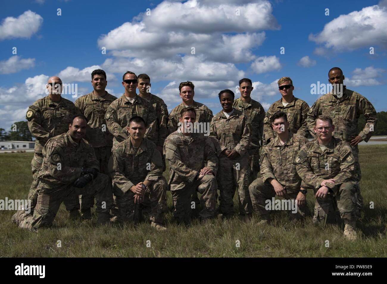 Members of the 820th Base Defense Group pose with Tech. Sgt. Joe Ostrum, 820th Combat Operations Squadron personal parachute program manager, front, third from the left, after he earned his senior-rated parachutist badge during a static-line jump, Oct. 3, 2017, at the Lee Fulp drop zone in Tifton, Ga. During a static-line jump, the jumper is attached to the aircraft via the ‘static-line’, which automatically deploys the jumpers’ parachute after they’ve exited the aircraft. Stock Photo