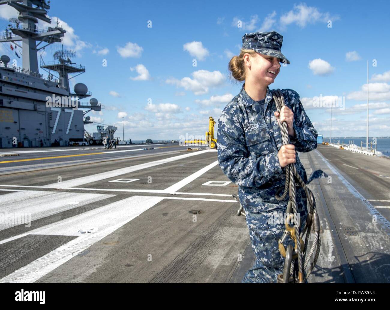NORFOLK, Va (Oct. 2, 2017) Aviation Boatswain's Mate (Equipment) Sarah Dudrey walks an arresting gear cable across the flight deck of the aircraft carrier USS George H.W. Bush (CVN 77). The ship is in port Norfolk, Virginia, conducting routine maintenance after a seven-month deployment in support of maritime security operations and theater security cooperation efforts in the U.S. 5th and 6th Fleet areas of responsibility. Stock Photo