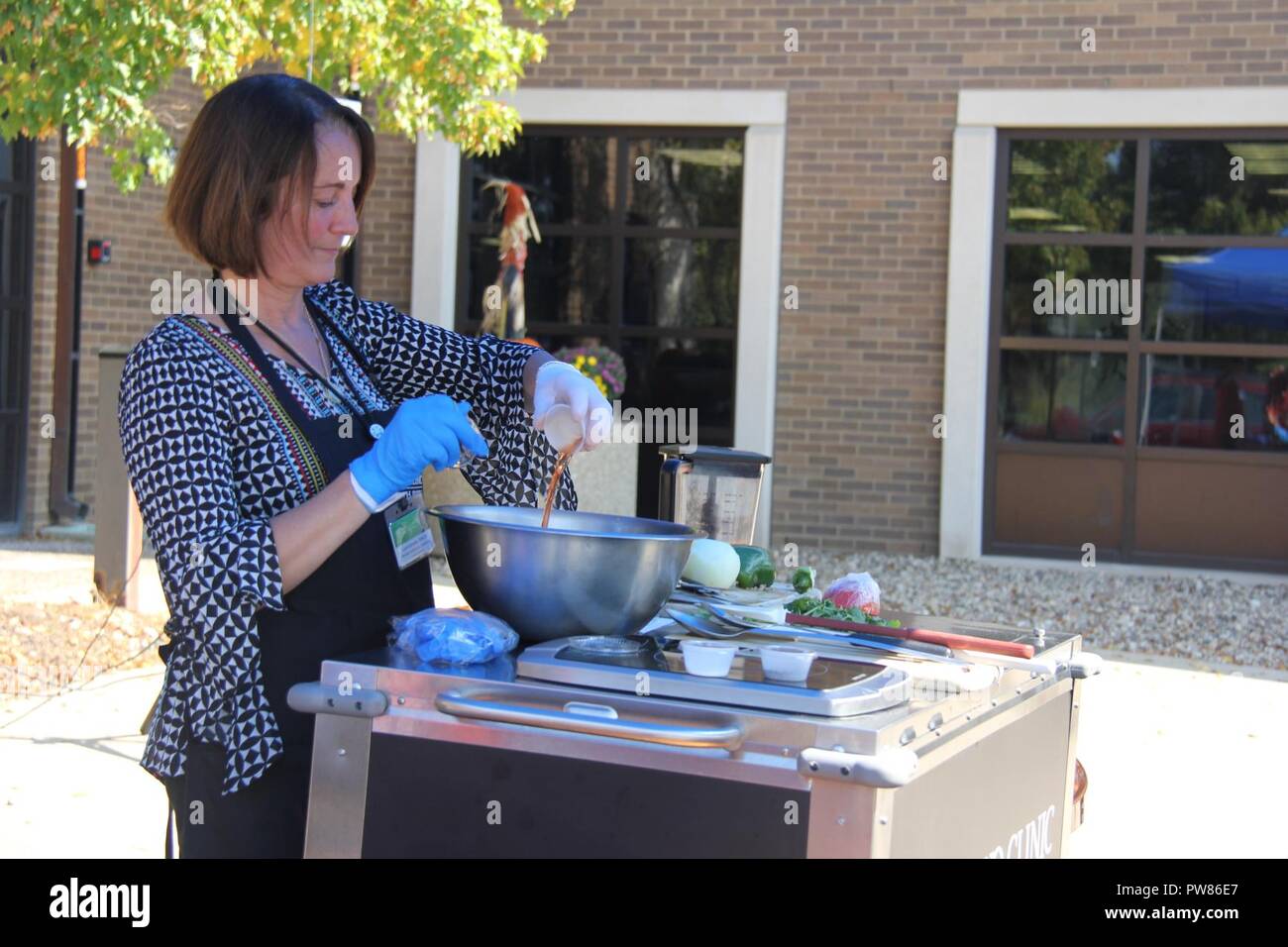 Lynn Edwards, registered dietitian nutritionist and certified dietitian with Morrison Healthcare, contracted through Mayo Clinic Health System, mixes ingredients for pico de gallo during a cooking demonstration Sept. 19, 2017, outside building 2187 at Fort McCoy, Wis. The demonstration was organized by the Civilian Personnel Advisory Center Wellness Committee, which promotes and encourages healthy lifestyles. Events are held on a regular basis throughout the year, including runs/walks, guest speakers, CPAC Wellness Challenge, and Salad Club. Stock Photo