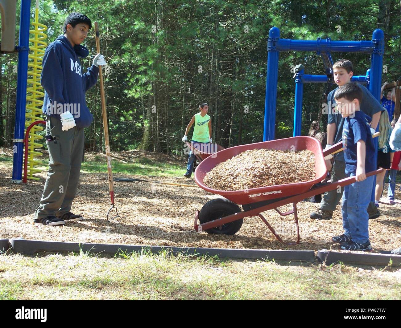 Boys work together to place mulch on the playground at West Hill Dam ...